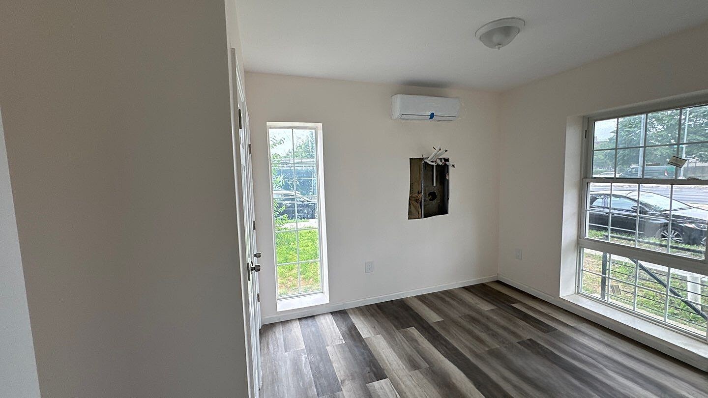 830 Hendrix Street Brooklyn, NY 11207 - Photo 22 of 25 an empty room with wooden floor and windows