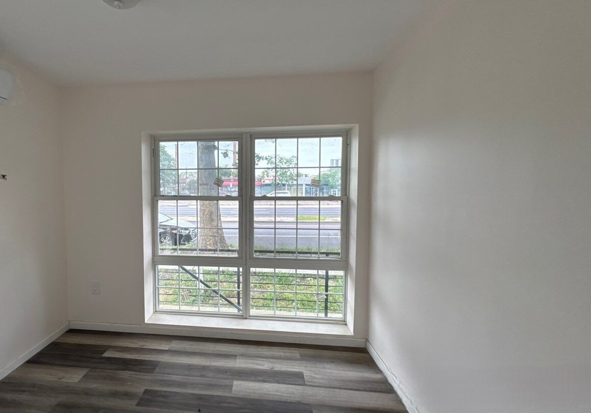830 Hendrix Street Brooklyn, NY 11207 - Photo 23 of 25 a view of an empty room with wooden floor and a window