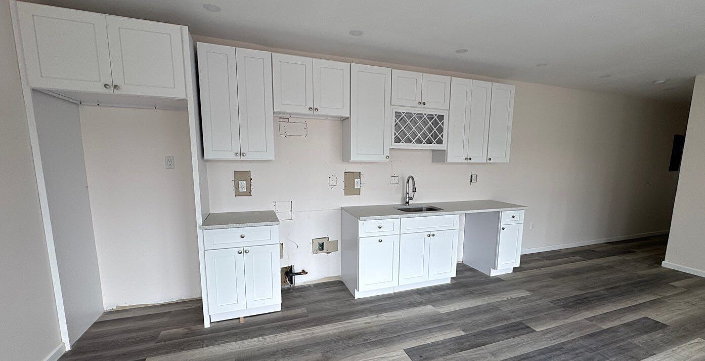 830 Hendrix Street Brooklyn, NY 11207 - Photo 5 of 25 a kitchen with white cabinets and stainless steel appliances