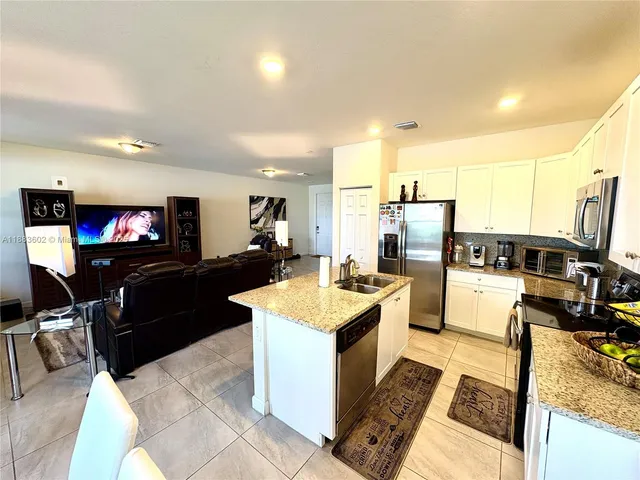 a large kitchen with stainless steel appliances kitchen island granite countertop a large island in the center