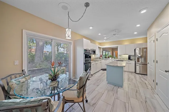 a view of a dining room and livingroom with furniture wooden floor a chandelier