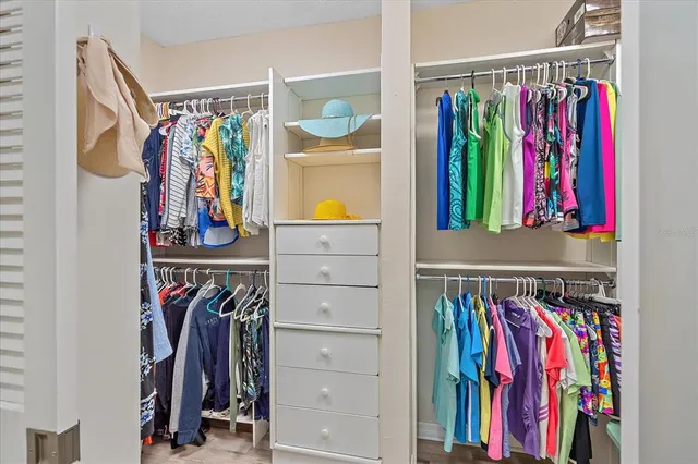 a view of walk in closet with clothes