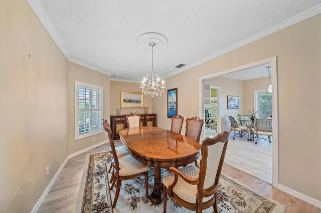 a dining room with furniture a chandelier and wooden floor