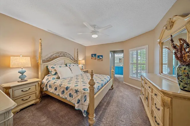 a bedroom with a bed a flat tv screen and dresser