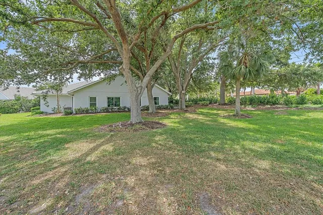 a view of a house with backyard and trees