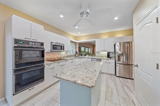 a kitchen with stainless steel appliances granite countertop a refrigerator and a stove top oven