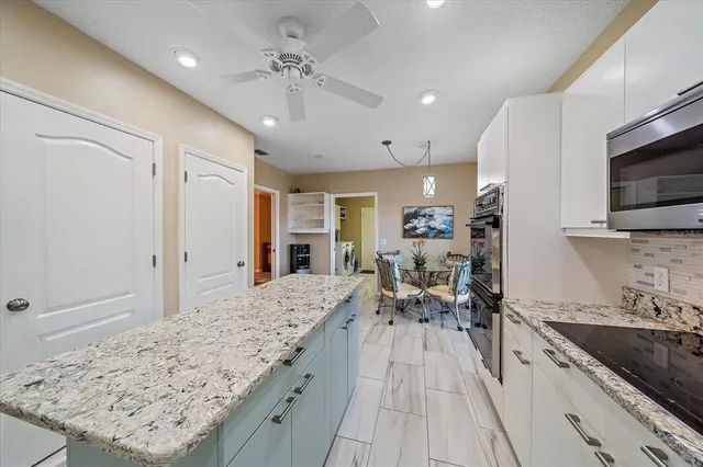 a large kitchen with kitchen island a sink stainless steel appliances and cabinets