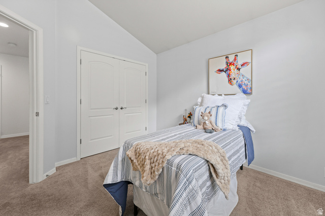 4668 Bountiful Ridge Drive Bountiful, UT 84010 - Photo 16 of 37 Carpeted room featuring a vaulted ceiling, white walls, and a double-door closet with arched paneling