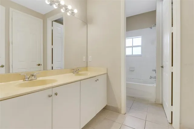 a spacious bathroom with a granite countertop sink a toilet mirror and bathtub