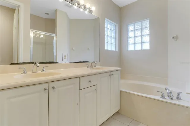 a bathroom with a tub a sink and mirror