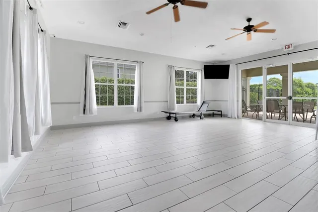 a view of empty room with floor to ceiling window and wooden floor