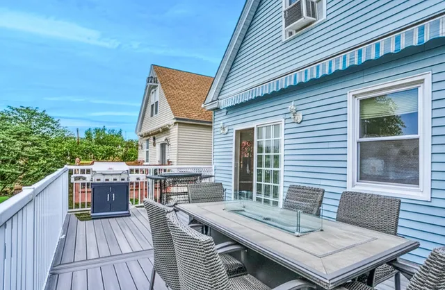 a view of a roof deck with table and chairs with wooden floor and fence
