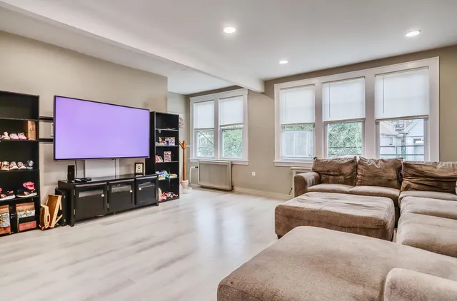 a living room with furniture a large window and a flat screen tv