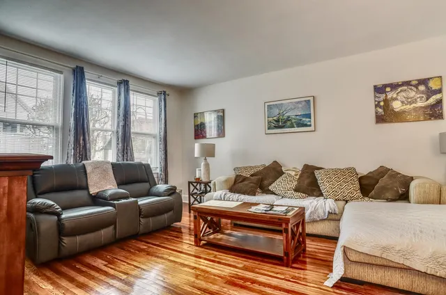 a living room with furniture wooden floor and a large window
