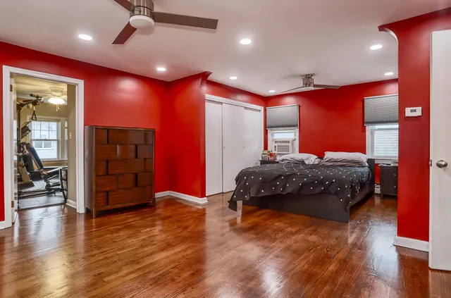 a bedroom with a large bed and wooden floor