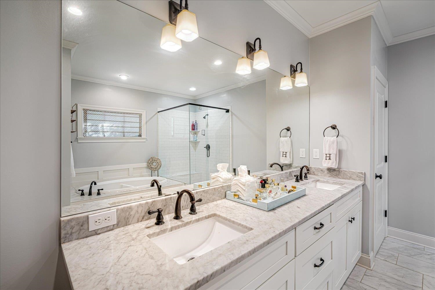 3682 Oakley Avenue Memphis, TN 38111 - Photo 22 of 34 a bathroom with double vanity sinks a large mirror and a shower