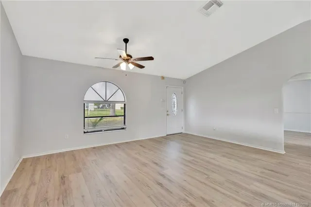 an empty room with wooden floor and window
