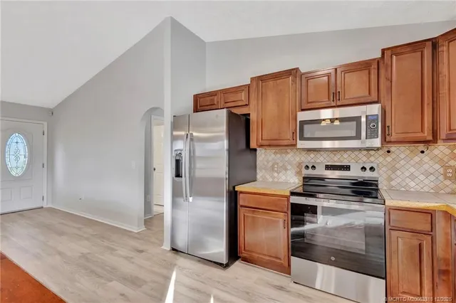 a kitchen with stainless steel appliances granite countertop a refrigerator stove and sink