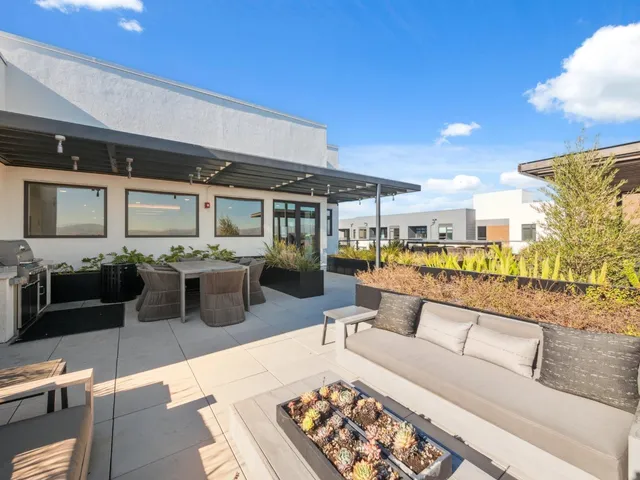 a living room with stainless steel appliances kitchen island granite countertop a table and chairs