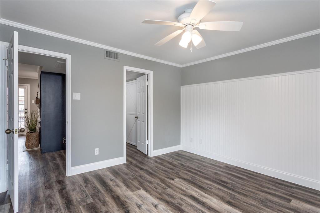16301 Ledgemont Lane, Unit 283 Addison, TX 75001 - Photo 10 of 16 Generous sized bedroom with light gray walls, wood-like flooring and ceiling fan. Bead-board decorative wall. Ensuite to bathroom.