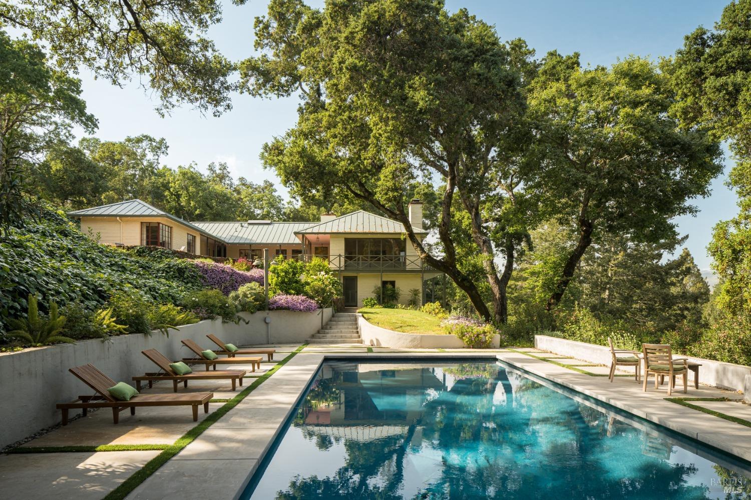 a view of backyard with swimming pool and seating space