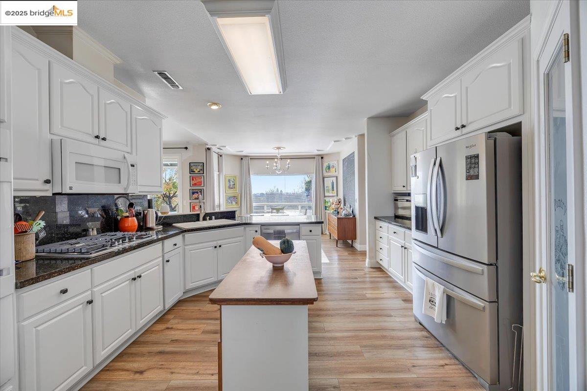 10200 Bell Mooney Road Jamestown, CA 95327 - Photo 18 of 60 a large kitchen with stainless steel appliances lots of counter space and wooden floor