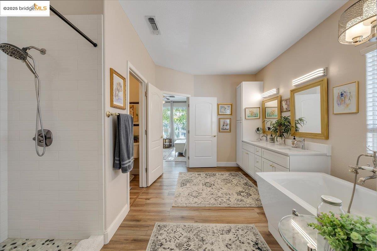 10200 Bell Mooney Road Jamestown, CA 95327 - Photo 26 of 60 Full bath featuring double vanity, light wood-style flooring, a freestanding bath, and tiled shower