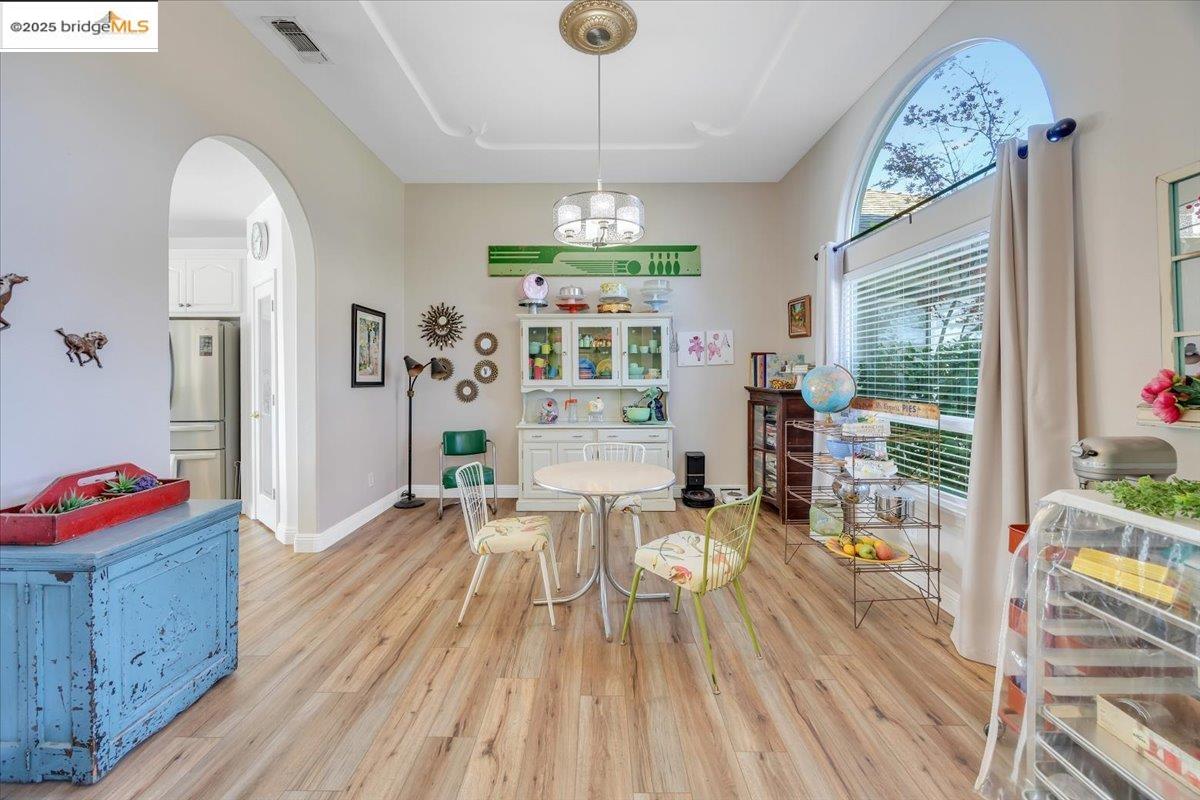 10200 Bell Mooney Road Jamestown, CA 95327 - Photo 10 of 60 Dining area featuring arched walkways, light wood-type flooring, and a chandelier