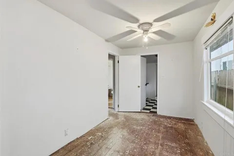 an empty room with closet and a ceiling fan