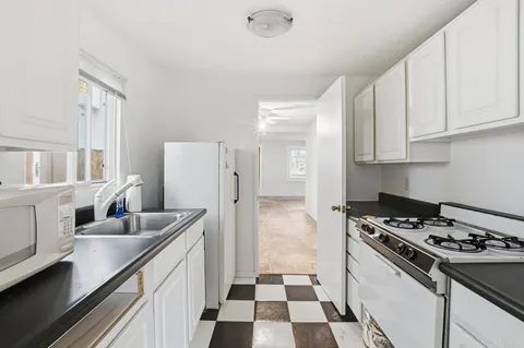 a kitchen with stainless steel appliances a sink a stove a refrigerator and cabinets