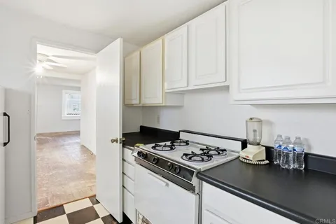 a kitchen with a stove and white cabinets