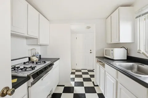 a kitchen with stainless steel appliances a stove a sink and a white cabinets