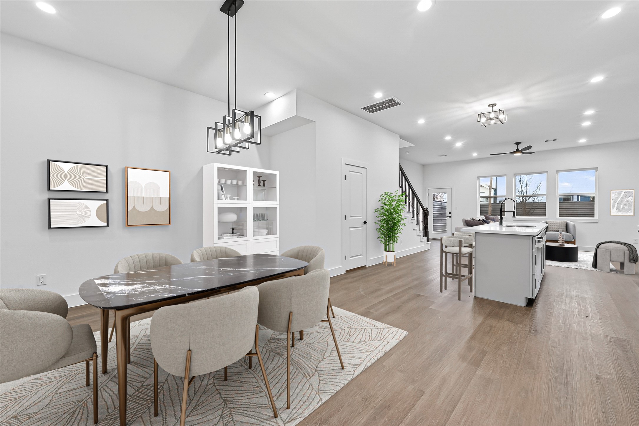 3514 Good Hope Street, Unit B Houston, TX 77021 - Photo 9 of 26 This modern open-concept space features a dining area with elegant lighting, a bright kitchen with a large island and bar seating, and a cozy living area. The room is enhanced by natural light from several windows, creating an inviting atmosphere.