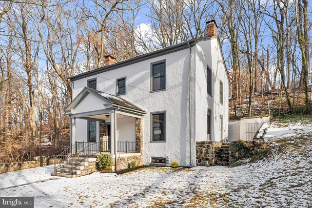 a front view of a house with a yard covered in snow