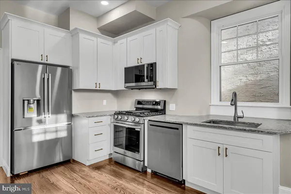 a kitchen with stainless steel appliances granite countertop a stove a sink and a refrigerator