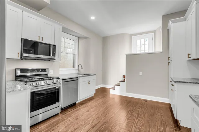 a kitchen with a stove a sink and a microwave