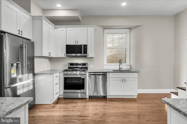 a kitchen with stainless steel appliances granite countertop a stove a sink and a refrigerator