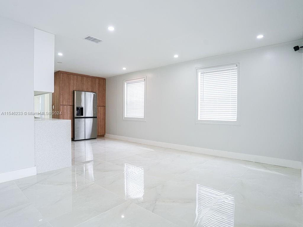 765 West 5th Street Riviera Beach, FL 33404 - Photo 5 of 27 a view of empty room with windows and refrigerator