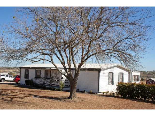 2318 Goforth Road Kyle, TX 78640 - Photo 1 of 1 Exterior Front : SITTING ON 5+/- ACRES, WITH ADD ON MASTER SUITE & COVERED PATIO, SUN ROOM, 4 BEDROOMS 2 OF THEM MASTER W/OWN BATH, GARAGE,WORKSHOP AND STORAGE...PLUS 2 OTHER MOBILES AND SPACE FOR 4TH! COME SEE THIS GREAT PROPERTY TODAY!