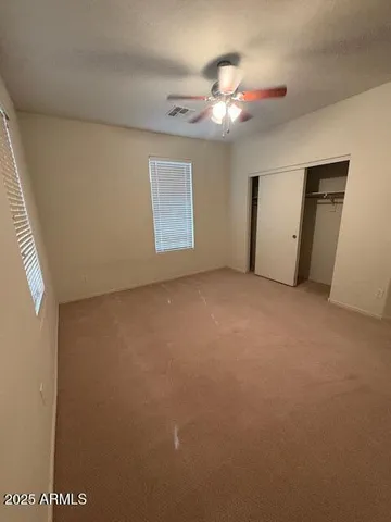 a view of an empty room with a chandelier fan