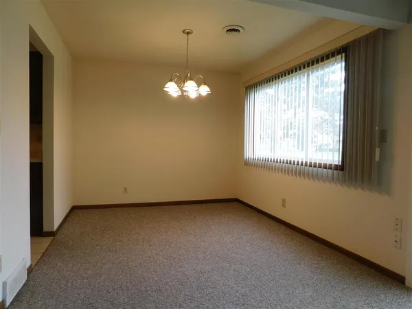 an empty room with a windows and chandelier
