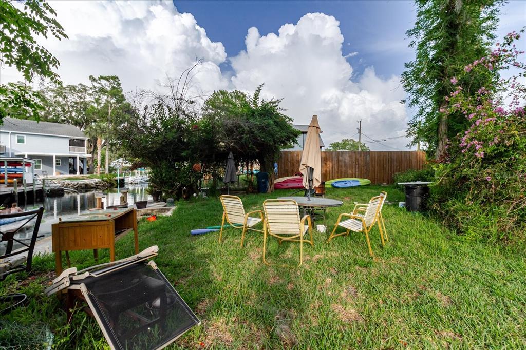 5323 Circle Drive Weeki Wachee, FL 34607 - Photo 63 of 77 a view of a patio with table and chairs potted plants and palm tree