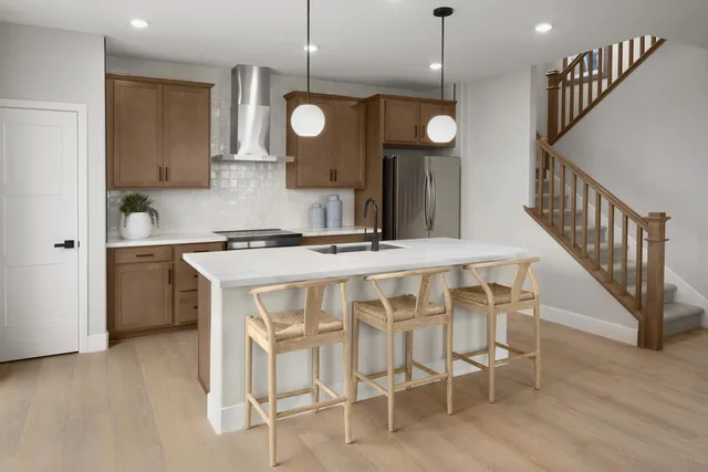 a kitchen with a dining table chairs sink and cabinets