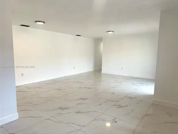 en empty room with white walls and tiles