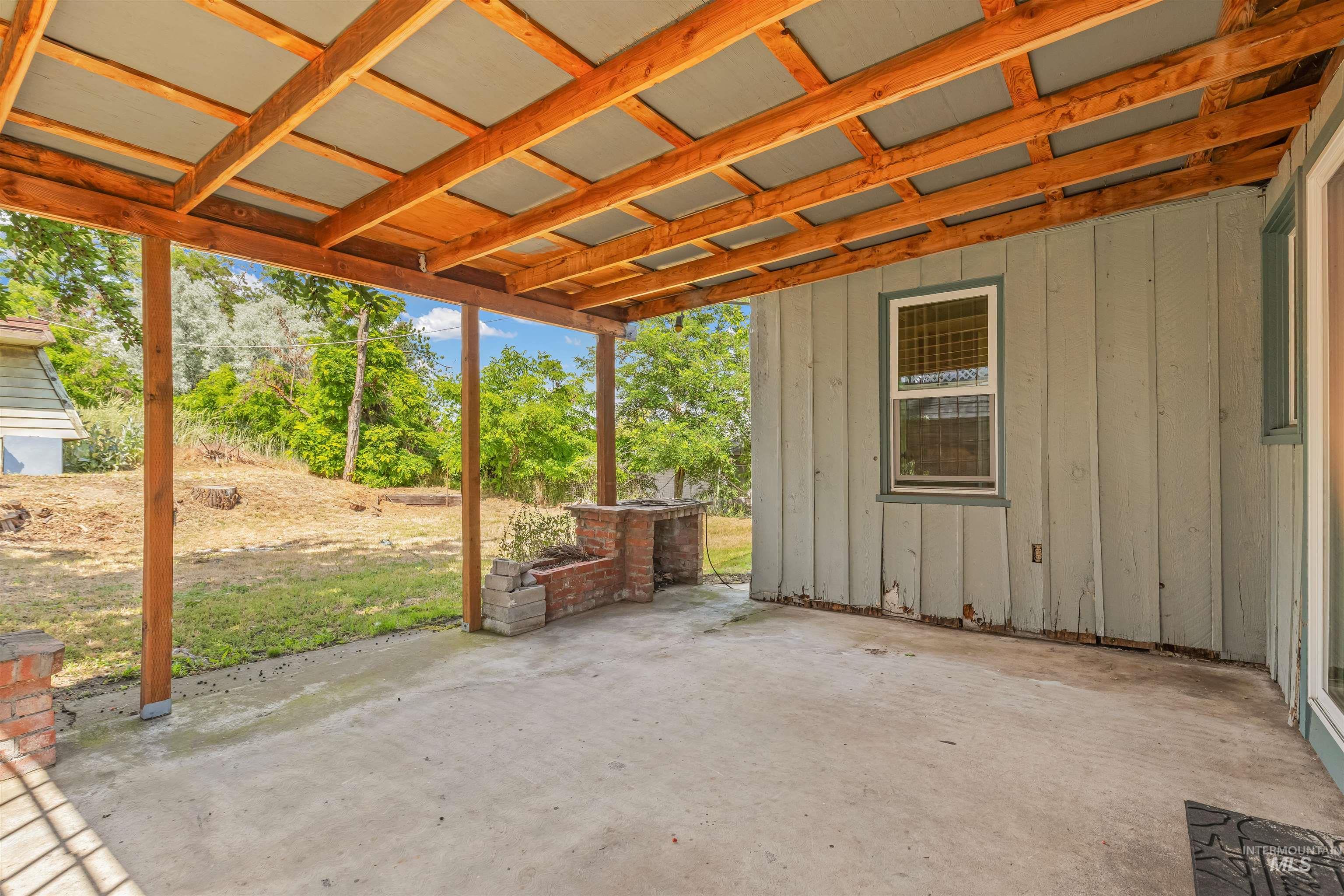 1663 9th Avenue Lewiston, ID 83501 - Photo 33 of 36 Covered patio featuring a concrete slab floor, exposed wood beam ceiling, and a built-in brick and concrete barbecue structure