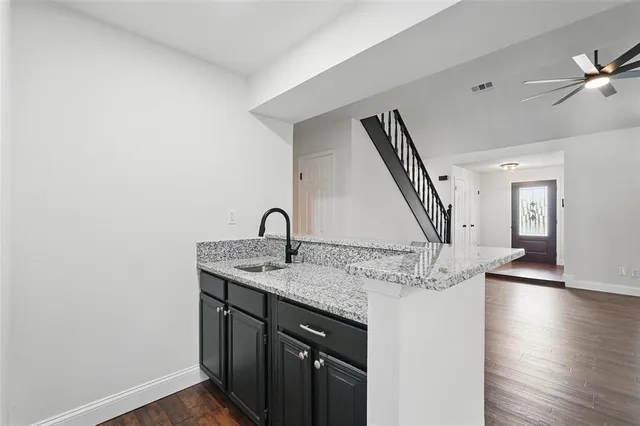 a kitchen with a sink a counter space and wooden floor