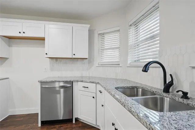 a view with a sink a microwave and cabinets