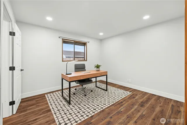 a living room with a rug and a wooden floor