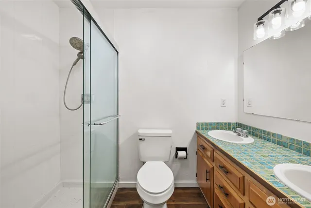 a bathroom with a granite countertop sink toilet and a mirror