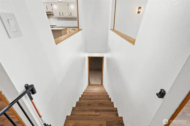 a view of a hallway with wooden floor and staircase
